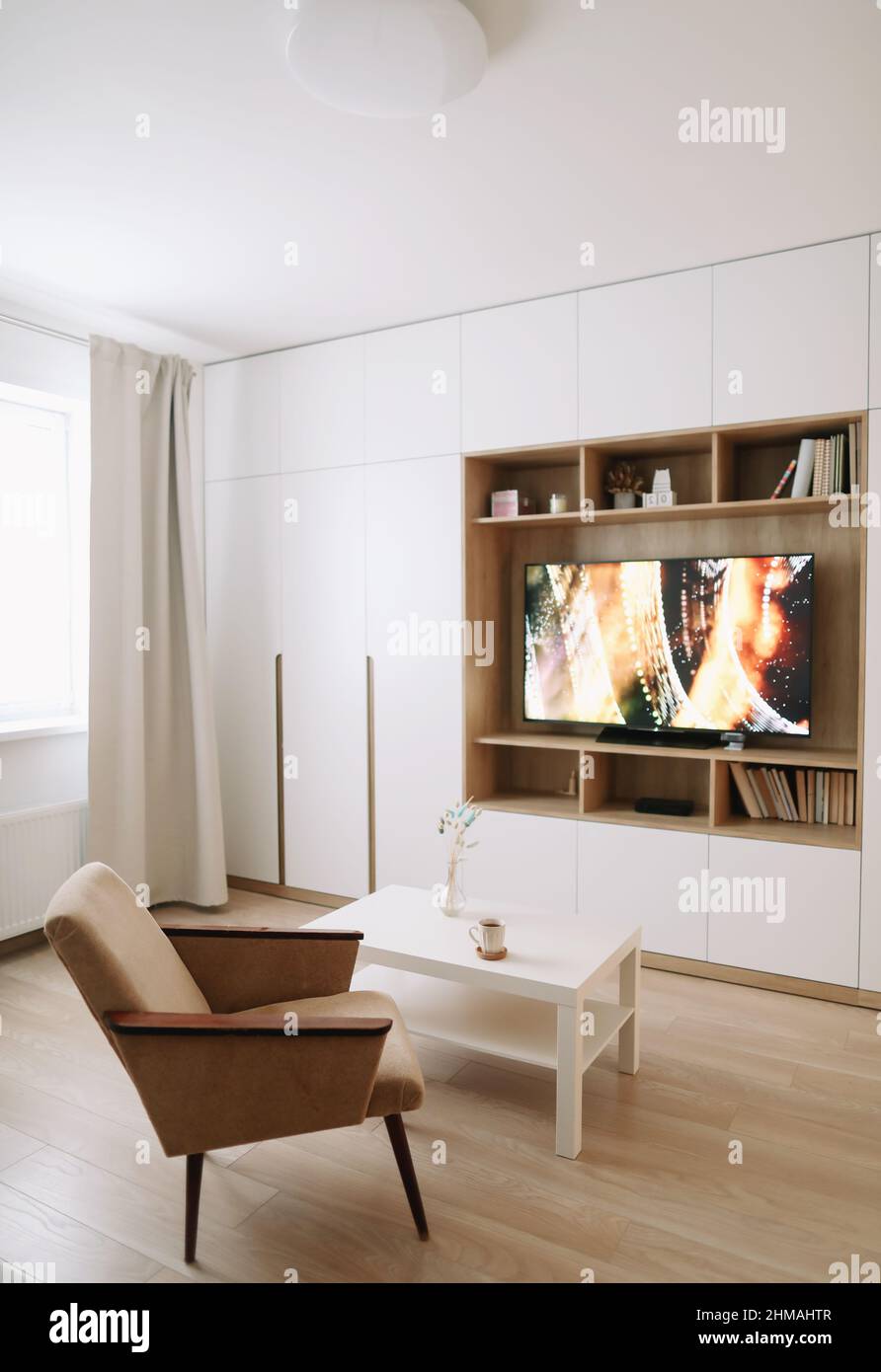 Elegante e moderno soggiorno interno design con TV, poltrona, tavolino da  caffè e una finestra con tende. Appartamento minimalista in affitto Foto  stock - Alamy