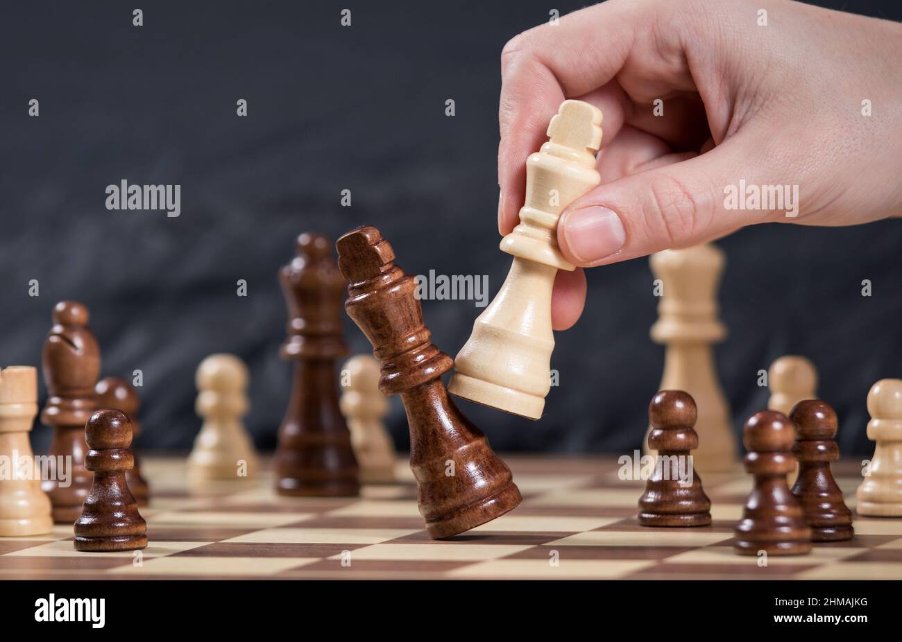 Successo, gestione e concetto di leadership aziendale, mano di uomo d'affari che muove scacchi re per vincere utilizzando la strategia e la pianificazione del leader Foto Stock