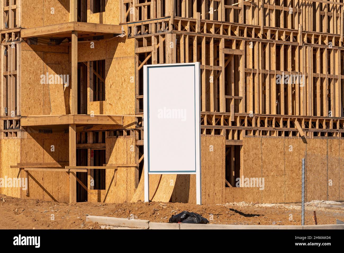 Scatto orizzontale di un segno bianco vuoto di fronte ad un nuovo edificio di appartamenti in costruzione.v Foto Stock