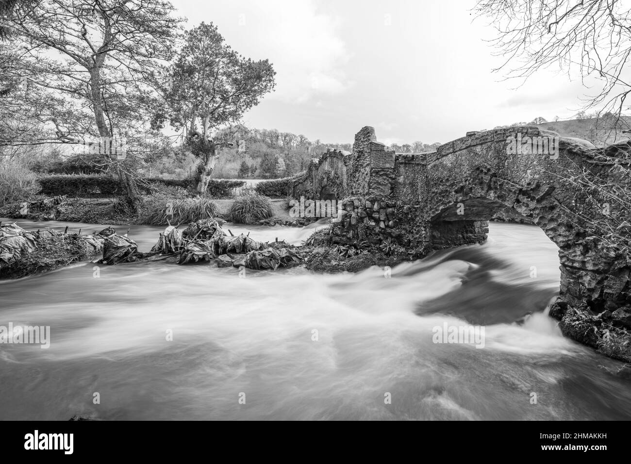 Lunga esposizione del fiume Avill che scorre sotto il ponte degli amanti nei terreni del castello di Dunster nel Somerset Foto Stock