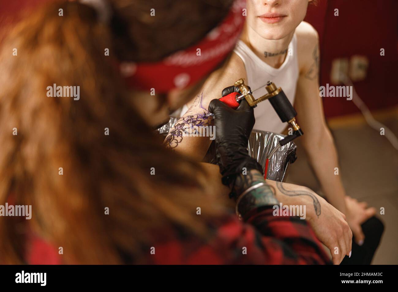 Primo piano delle mani della macchina del tatuaggio del padrone di tenuta Foto Stock