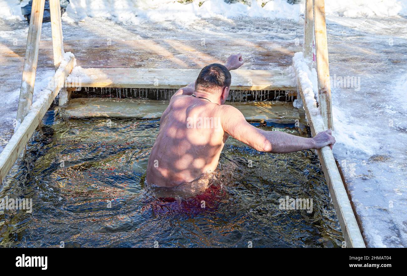 Nuoto invernale nella buca di ghiaccio sul fiume Foto Stock