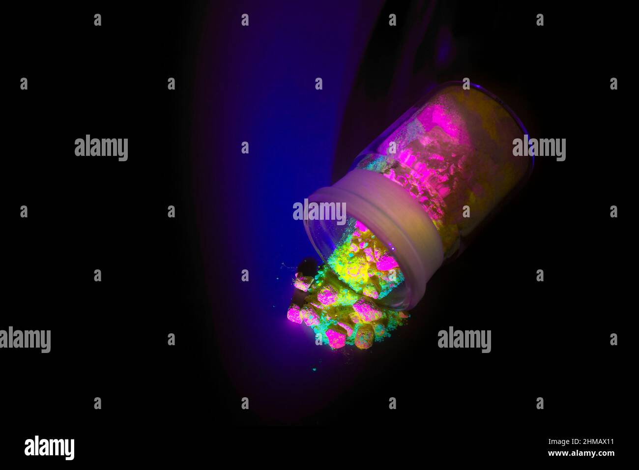 Materiali organici fluorescenti come una polvere di colore rosso, giallo e verde per la produzione di OLED all'interno di bottiglie di vetro in luce UV. Foto Stock