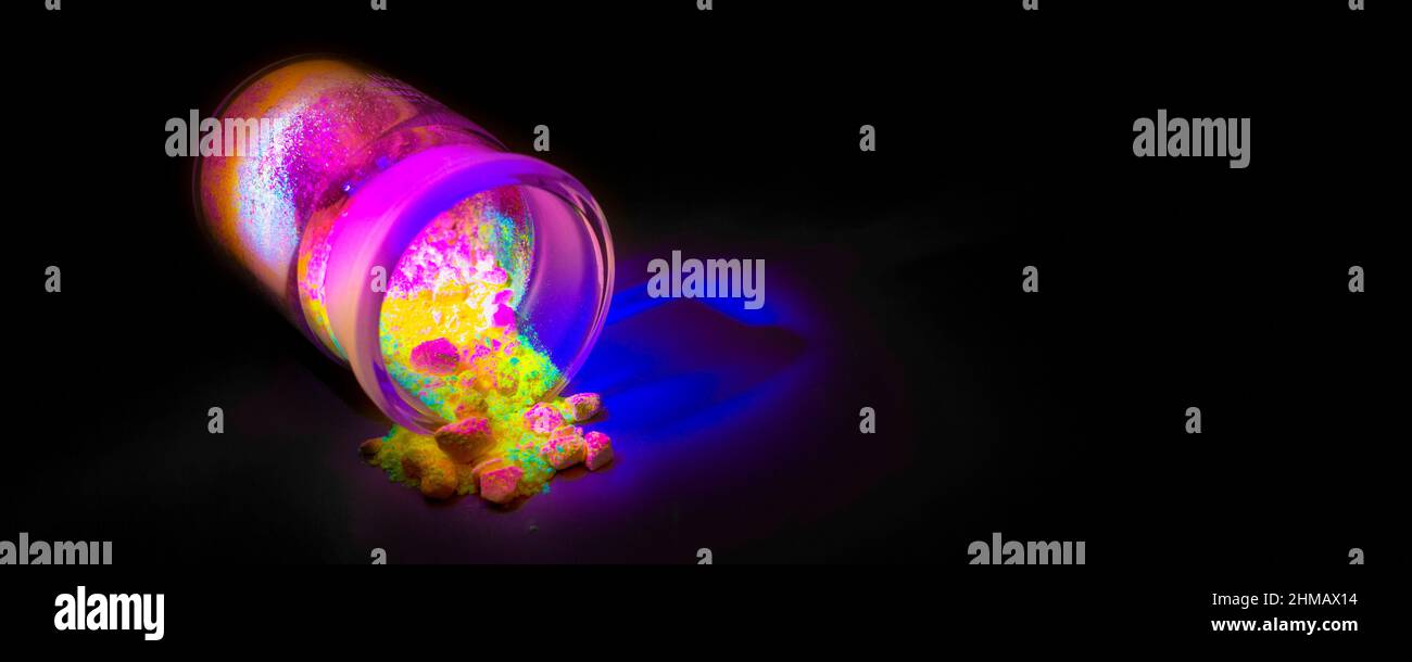 Materiali organici fluorescenti come una polvere di colore rosso, giallo e verde per la produzione di OLED all'interno di bottiglie di vetro in luce UV. Foto Stock