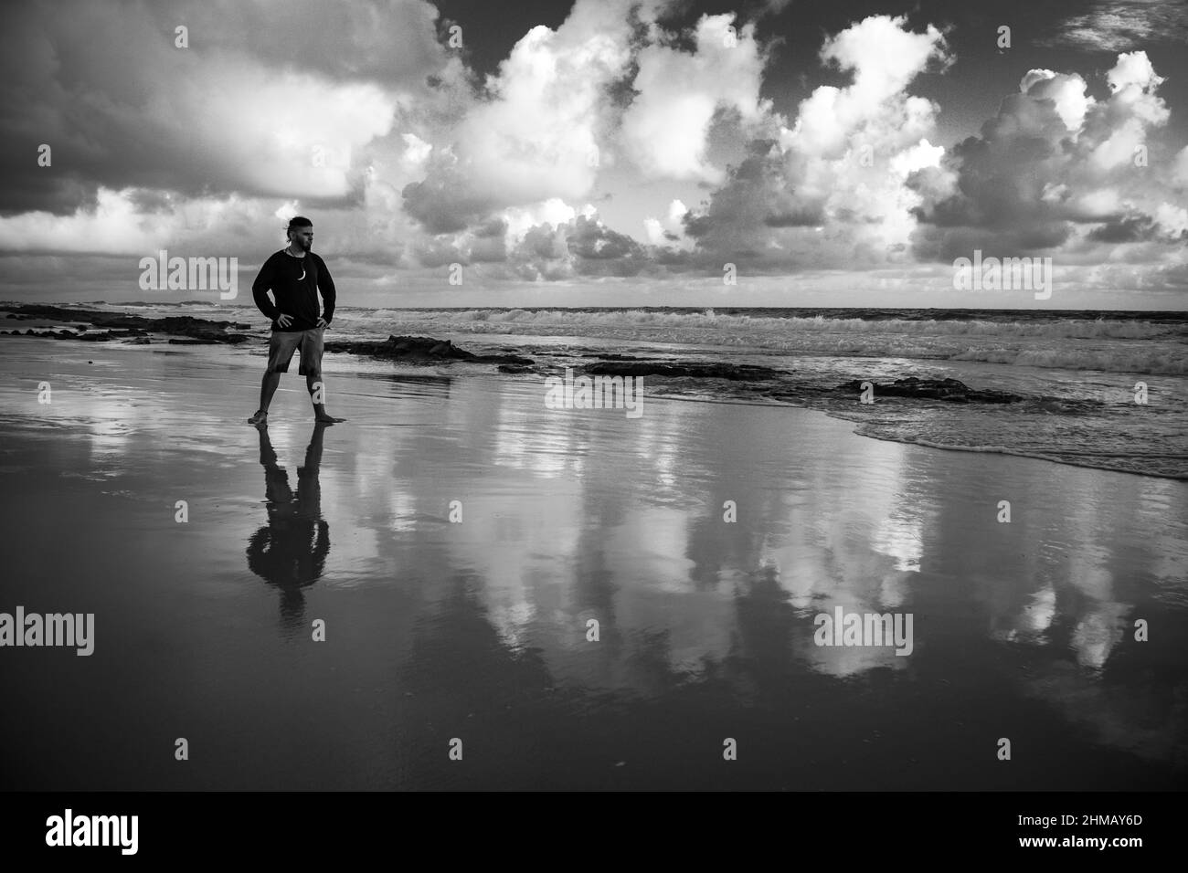 Uomo felice sulla spiaggia. Atteggiamento positivo di un giovane all'alba. Foto Stock