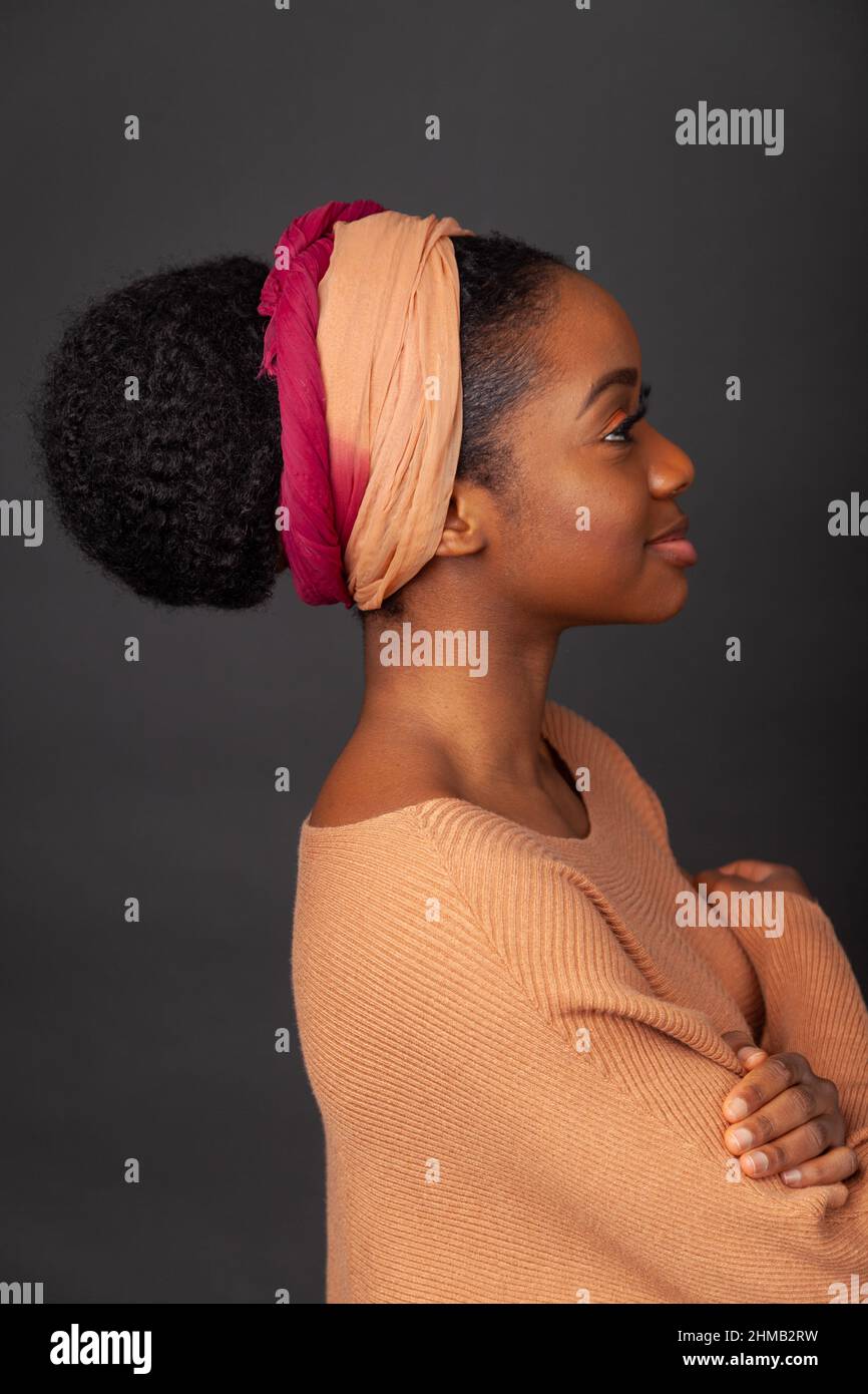Un ritratto da vicino di una donna nera con i capelli legati alla schiena e indossando e la banda di capelli. Foto Stock