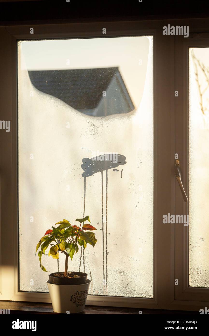 Un foro pulito in una finestra coperta di condensa. Foto Stock