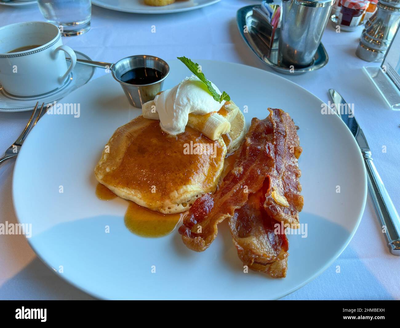 Port Canaveral, FL USA - 15 gennaio 2022: Frittelle di latticello, pancetta e caffè colazione in un ristorante su una nave da crociera. Foto Stock