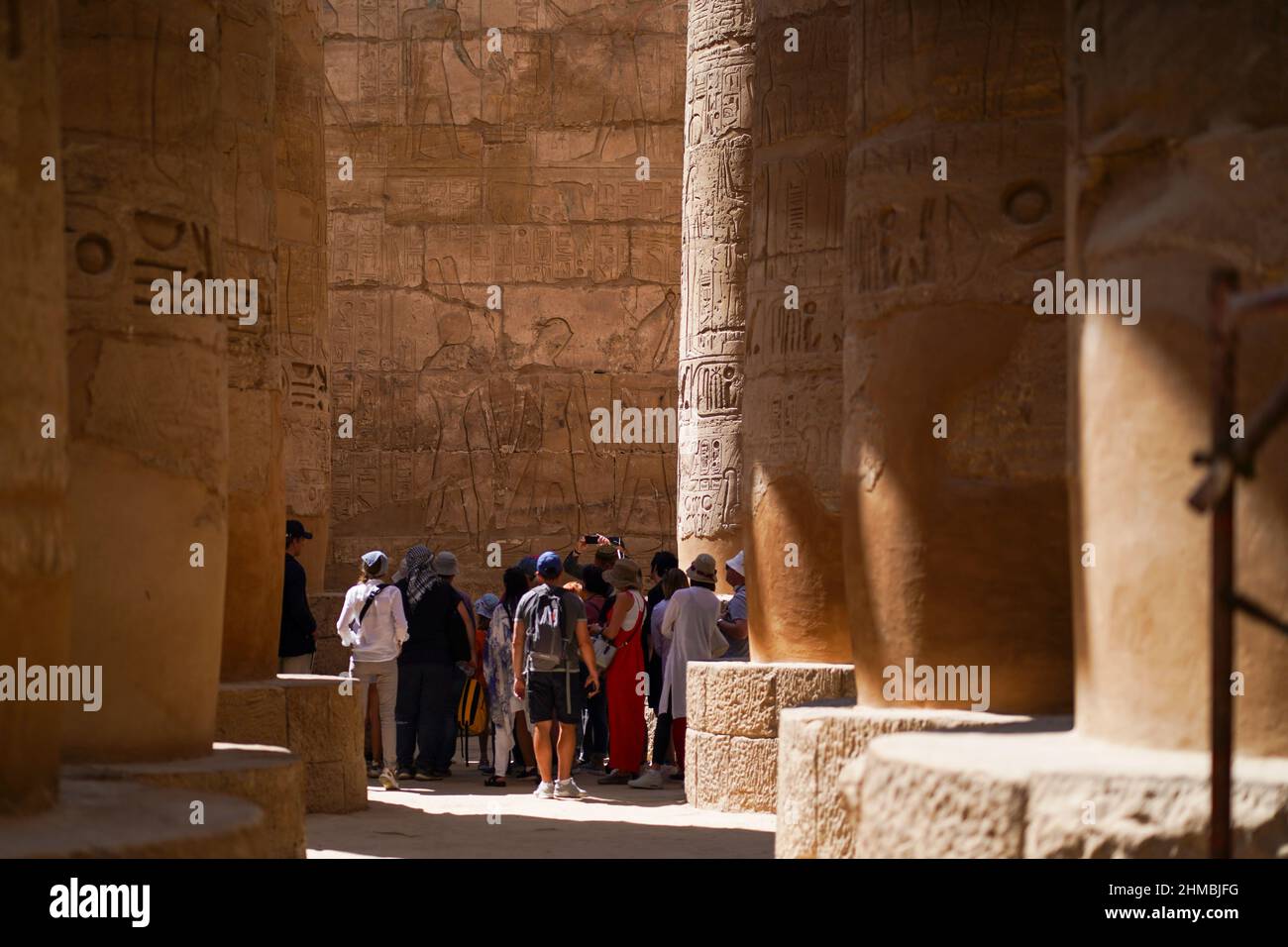 Un gruppo di turisti legge gli antichi geroglifi sulle mura del tempio di Luxor in Egitto. Foto Stock