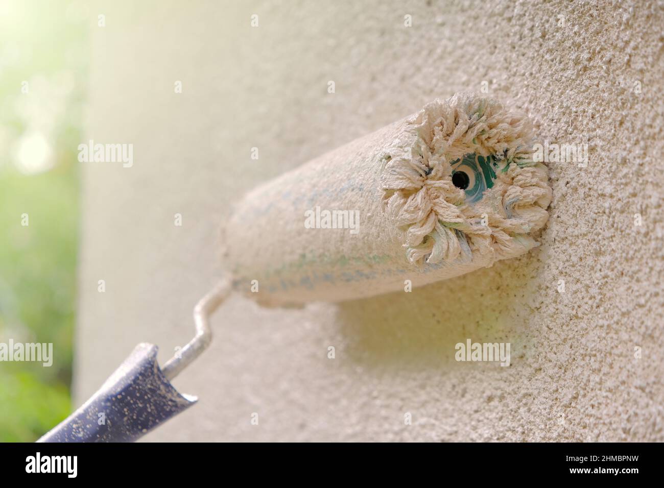 Rullo che dipinge le pareti della casa in beige color.wall painting.Construction rullo in vernice su un beige wall.House pittura in toni beige Foto Stock