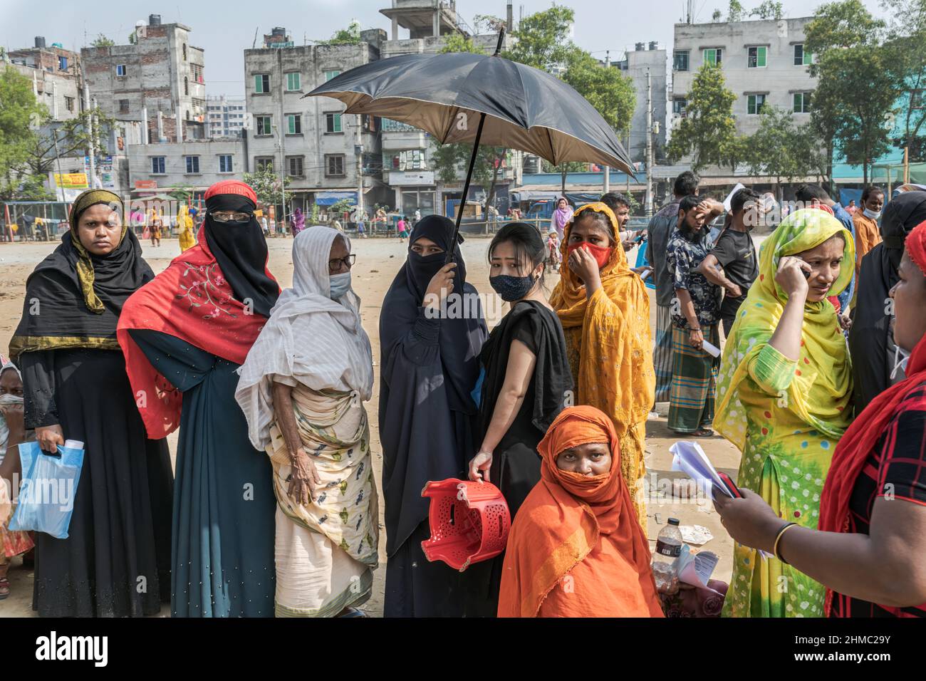 Gruppo di donne in attesa di essere vaccinate contro le COVID19 durante la campagna di vaccinazione a Mirpur.a Dhaka, Bangladesh, la capitale del paese più densamente popolato del mondo, la pandemia COVID è stata una storia caotica da quando le restrizioni governative hanno iniziato a cercare di prevenire infezioni e morti. Dhaka è una crescente megacità con più di 20 milioni di abitanti al rumore e la corsa quotidiana, ma senza le infrastrutture necessarie e con più del 60% della sua popolazione che lavora informalmente e impantanato in povertà, il caos si è intensificato a tutti i livelli. (Foto di Israel Fuguemann/SOPA im Foto Stock