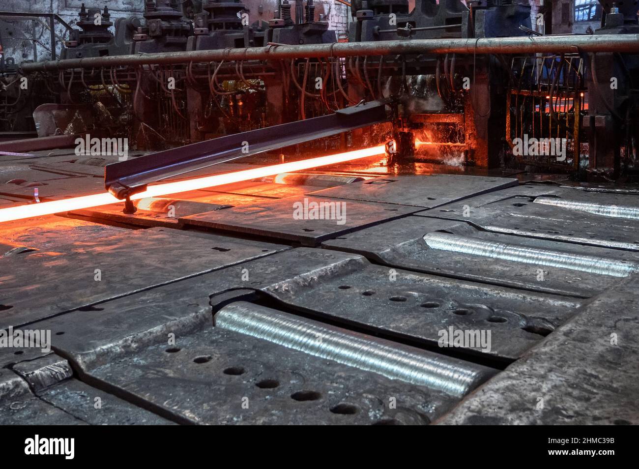 Il laminatoio in funzione. Il metallo caldo viene fatto rotolare attraverso rulli raffreddati Foto Stock