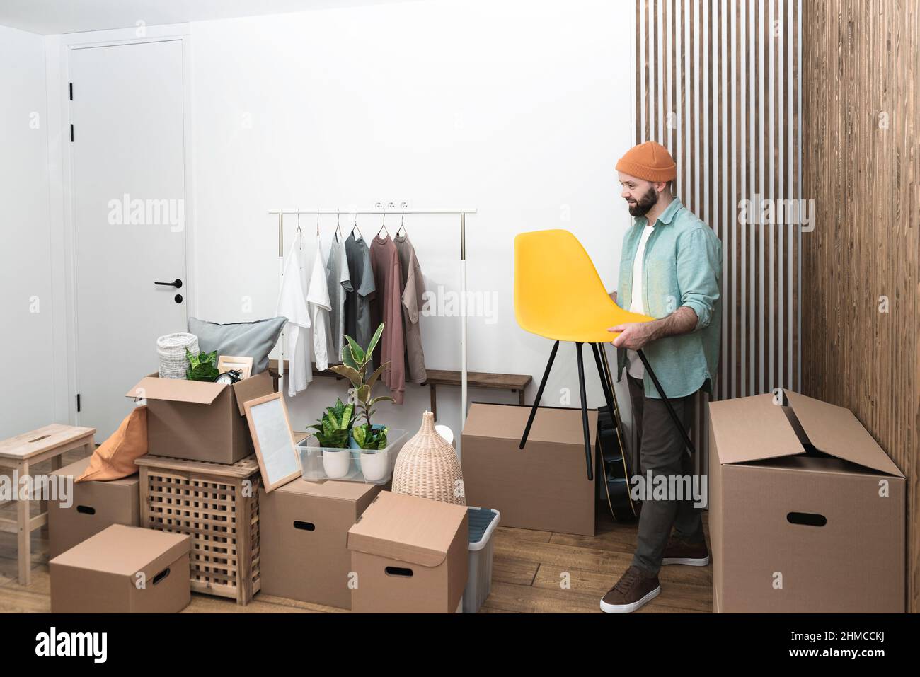 Gli uomini adulti disimballano le scatole in nuova sede il giorno in movimento. Foto di alta qualità Foto Stock