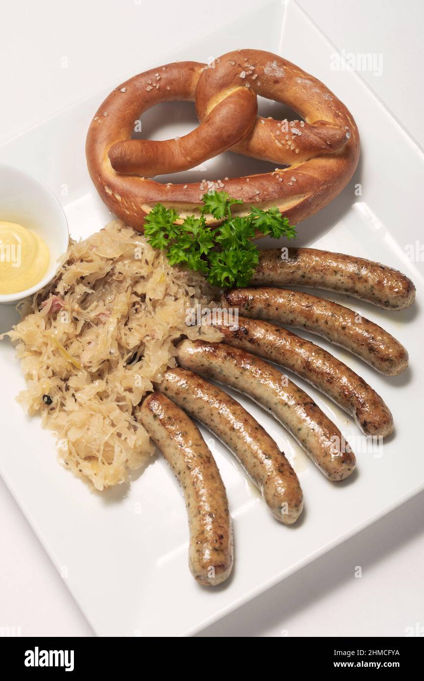 salsiccia con crauti e pretzel tradizionale pasto tedesco su sfondo bianco Foto Stock