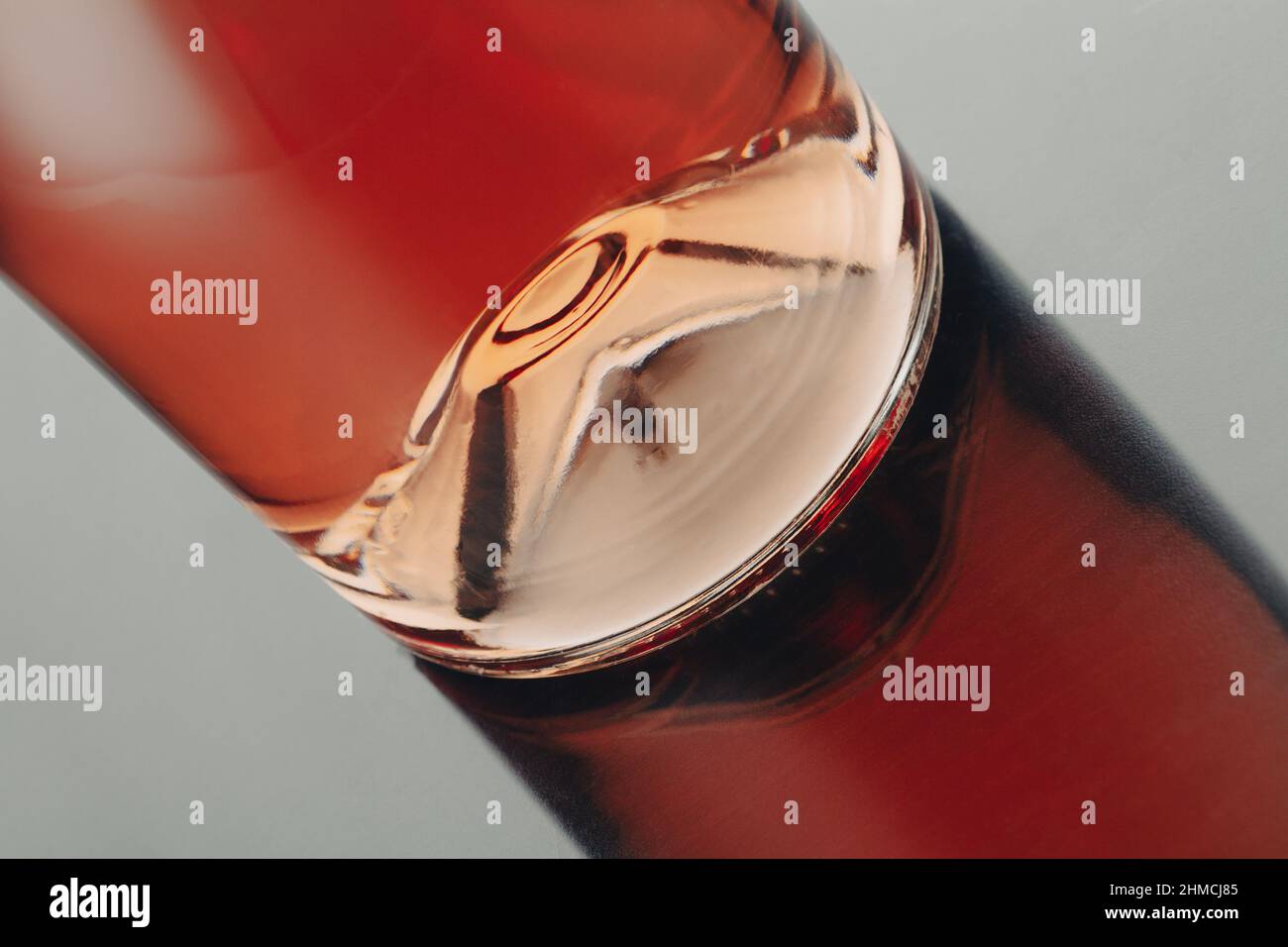 vista frontale primo piano di una bottiglia di vino rosa con riflessi sulla superficie lucida Foto Stock