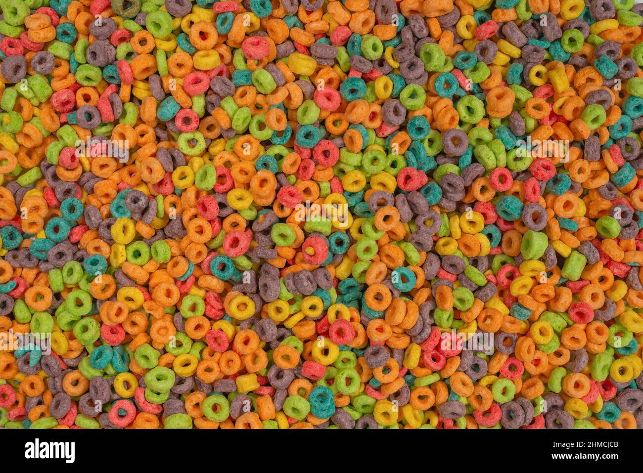 Dolci fiocchi multicolore, anelli di cereali come sfondo. Foto Stock