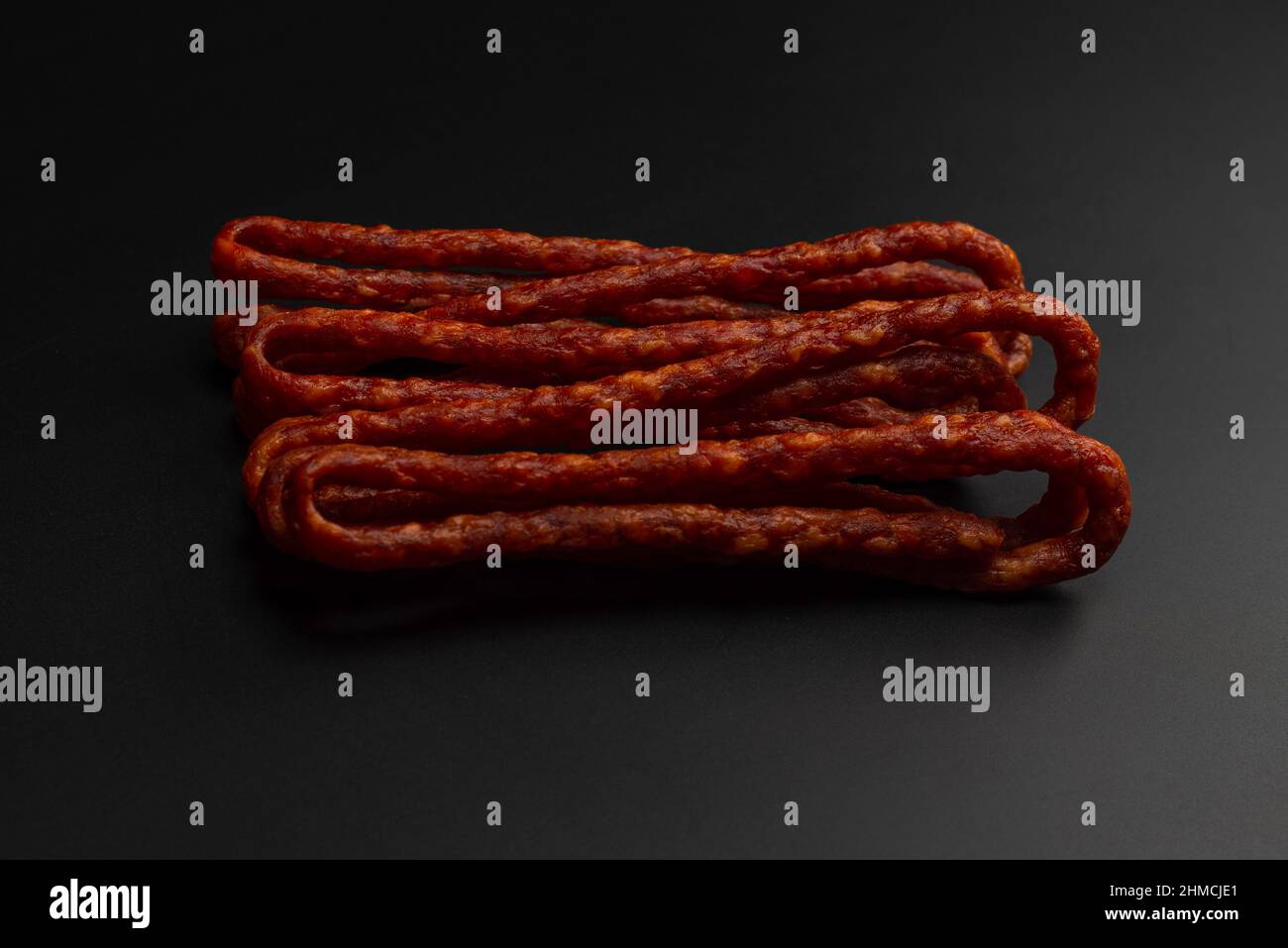 Cabanossi, salsiccia secca isolato su sfondo nero. Foto Stock