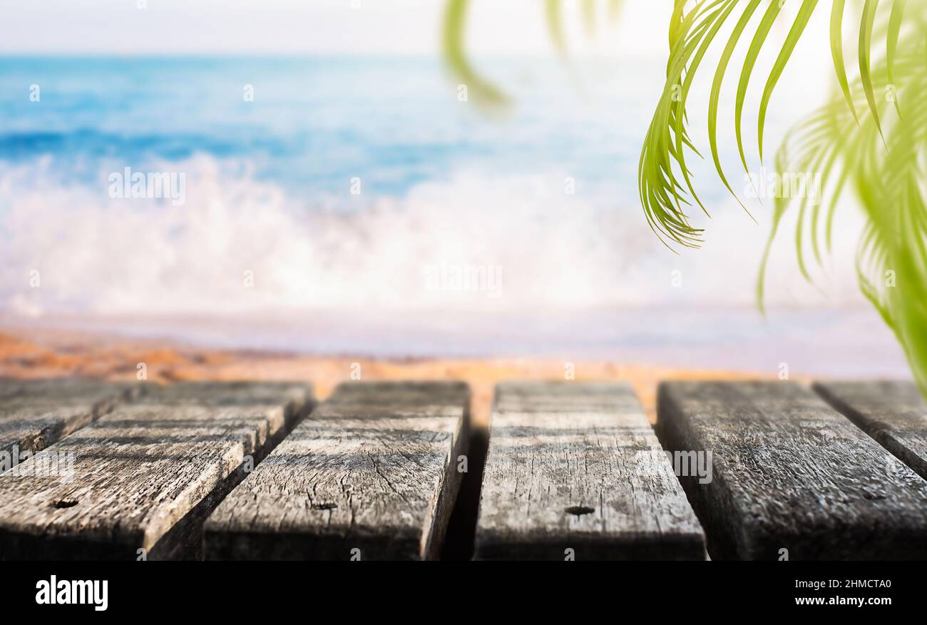 Sfondo vacanza. Doga di legno con foglie di palma sulla spiaggia Foto Stock