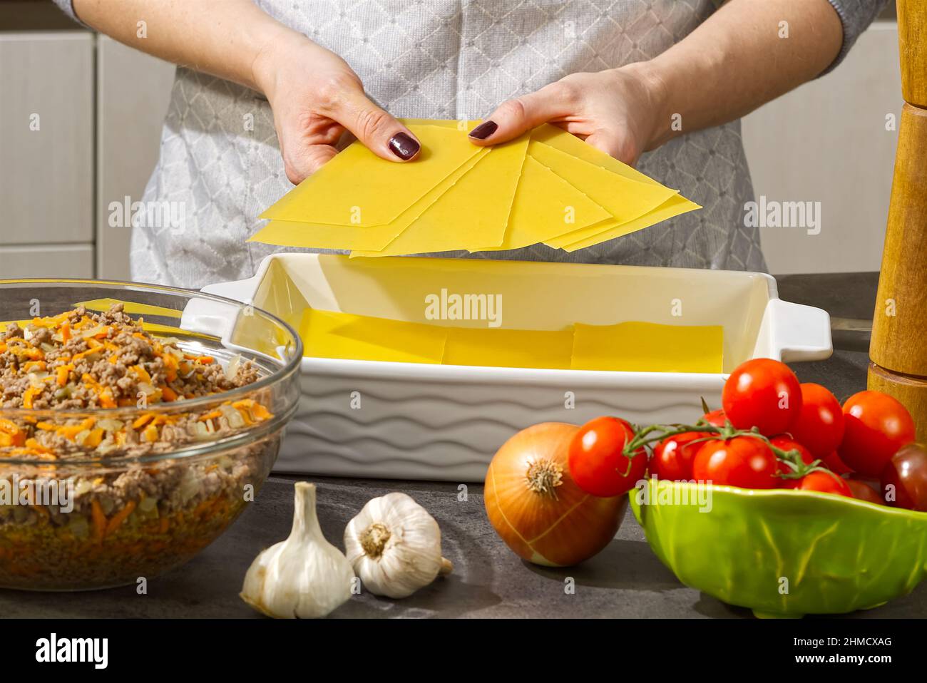 Donna che prepara lasagne di carne in cucina. Ricetta lasagna - cucina italiana Foto Stock
