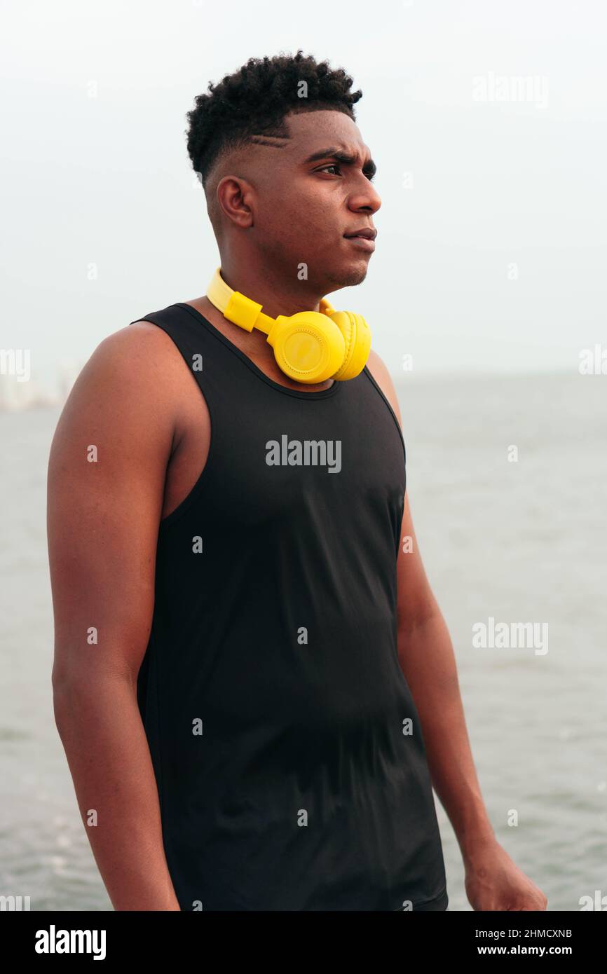 Uomo in abbigliamento sportivo con cuffie sulla strada per la palestra Foto Stock