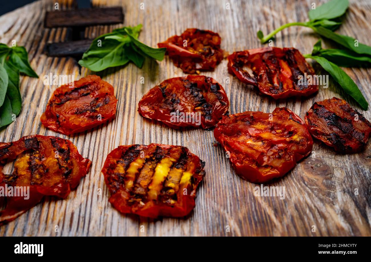 Pomodori ciliegini alla griglia su tavola di legno Foto Stock