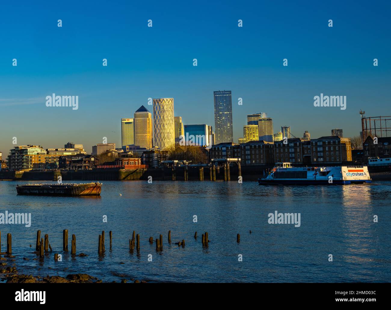 Canary Wharf, Tamigi, tramonto, giorno di sole, ora d'oro, City Cruisers, 1 canada Square. Cielo blu. Foto Stock