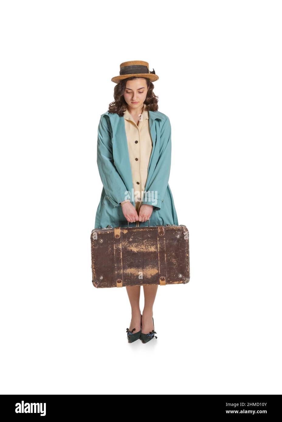 Triste giovane bella ragazza in stile retrò vestito, moda di 70s, 80s anni in piedi con valigia isolato su sfondo bianco studio. Vintage Foto Stock