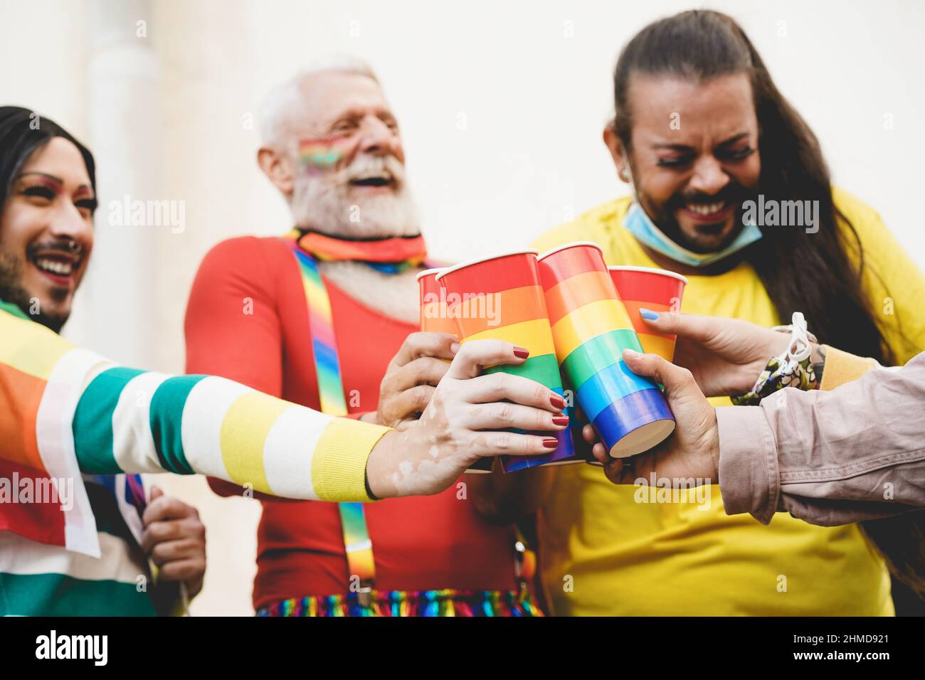 Buona gente gay che gridano con gli occhiali LGBT arcobaleno all'aperto orgoglio durante l'epidemia di coronavirus - Focus sulla mano sinistra Foto Stock