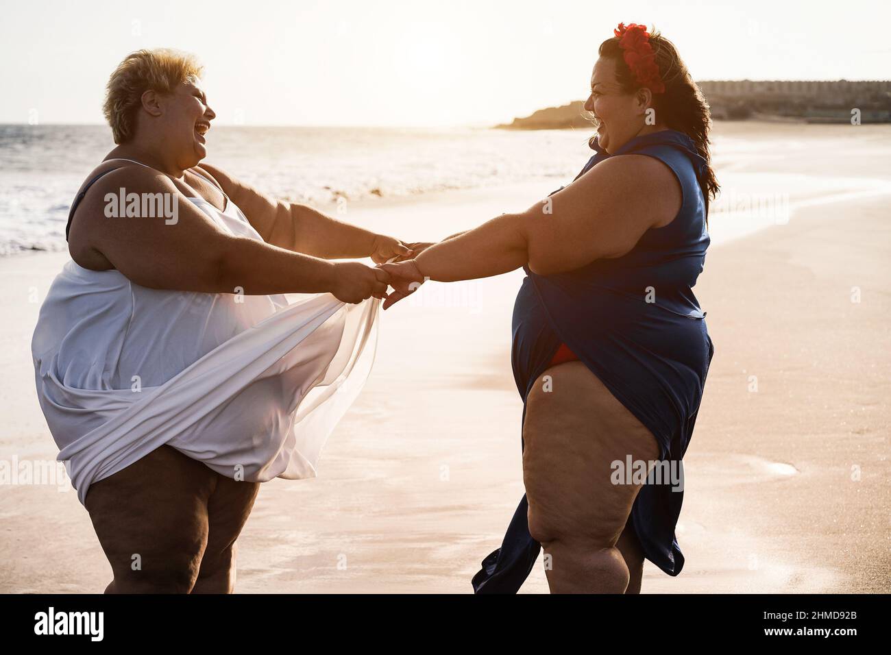 Donne curvate che ballano sulla spiaggia divertirsi durante le vacanze estive - Focus on Faces Foto Stock