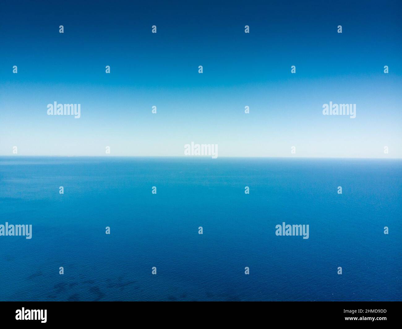 Calmo mare blu contro cielo limpido Foto Stock