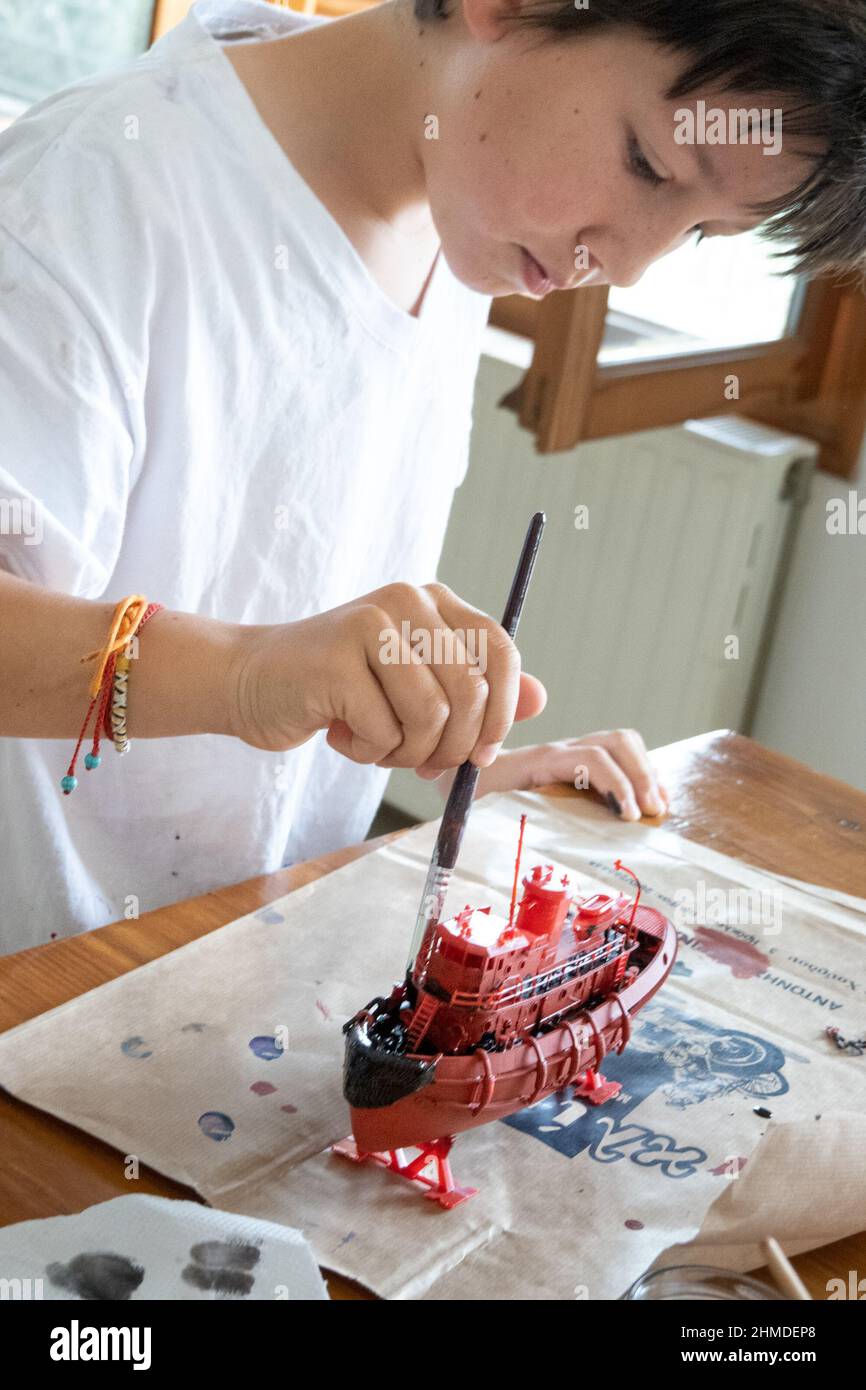 Boy colorare nave giocattolo in legno a casa Foto Stock