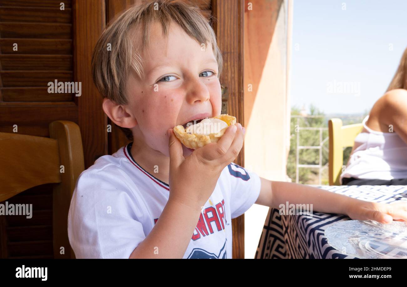 Ritratto di ragazzo mangiare crostata al ristorante Foto Stock