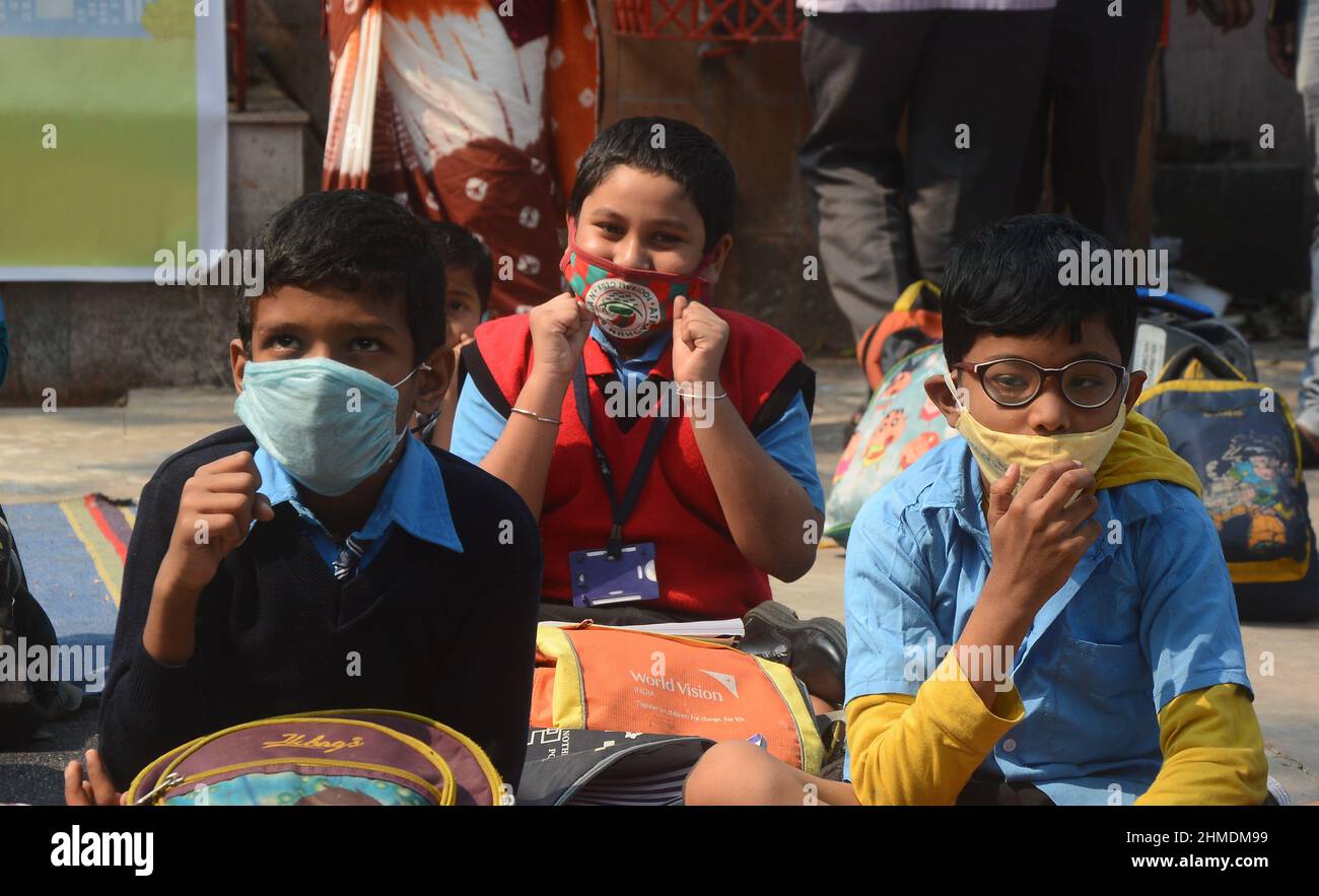 Kolkata, Bengala Occidentale, India. 8th Feb 2022. Le sorelle giocavano con gli studenti in un'aula all'aperto. Gli studenti sono venuti a terra la mattina per lo studio. Si siedono a terra mantenendo protocolli covidi. Indossano maschere. Gli studenti dello stato non sono stati in grado di andare a scuola per molto tempo. Specialmente studenti di classe inferiore. In quest’ottica, il governo statale sta lanciando un progetto per insegnare ai bambini in diverse parti del paese. È stato chiamato ''˜Paraya Shikshalay'. Gli studenti saranno insegnati in uno spazio aperto nel quartiere. L'obiettivo di questo progetto è Th Foto Stock