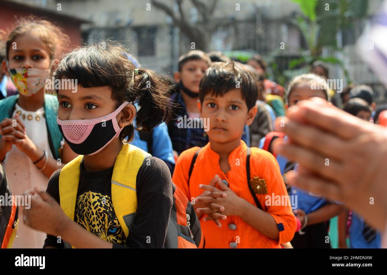 Kolkata, Bengala Occidentale, India. 8th Feb 2022. Le sorelle giocavano con gli studenti in un'aula all'aperto. Gli studenti sono venuti a terra la mattina per lo studio. Si siedono a terra mantenendo protocolli covidi. Indossano maschere. Gli studenti dello stato non sono stati in grado di andare a scuola per molto tempo. Specialmente studenti di classe inferiore. In quest’ottica, il governo statale sta lanciando un progetto per insegnare ai bambini in diverse parti del paese. È stato chiamato ''˜Paraya Shikshalay'. Gli studenti saranno insegnati in uno spazio aperto nel quartiere. L'obiettivo di questo progetto è Th Foto Stock
