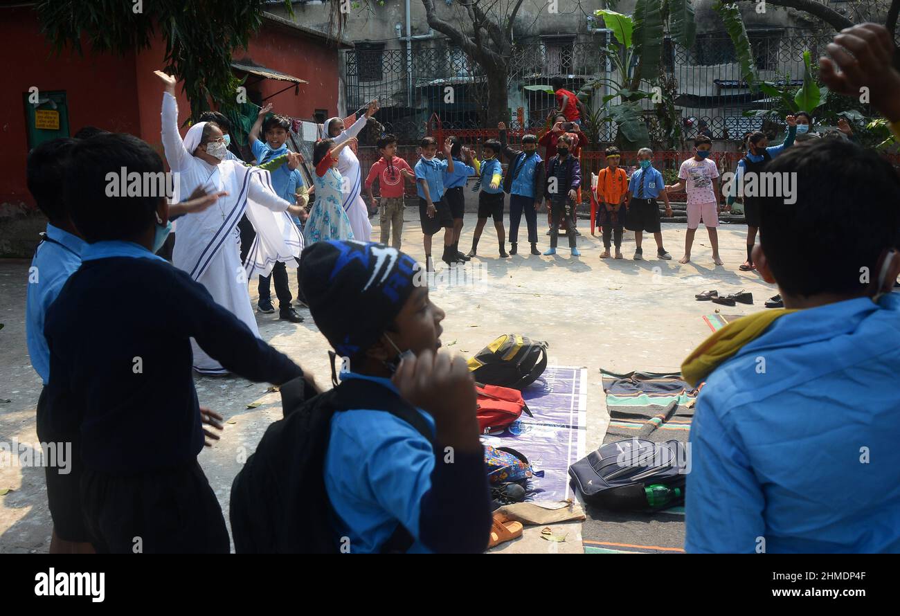 Kolkata, Bengala Occidentale, India. 8th Feb 2022. Le sorelle giocavano con gli studenti in un'aula all'aperto. Gli studenti sono venuti a terra la mattina per lo studio. Si siedono a terra mantenendo protocolli covidi. Indossano maschere. Gli studenti dello stato non sono stati in grado di andare a scuola per molto tempo. Specialmente studenti di classe inferiore. In quest’ottica, il governo statale sta lanciando un progetto per insegnare ai bambini in diverse parti del paese. È stato chiamato ''˜Paraya Shikshalay'. Gli studenti saranno insegnati in uno spazio aperto nel quartiere. L'obiettivo di questo progetto è Th Foto Stock