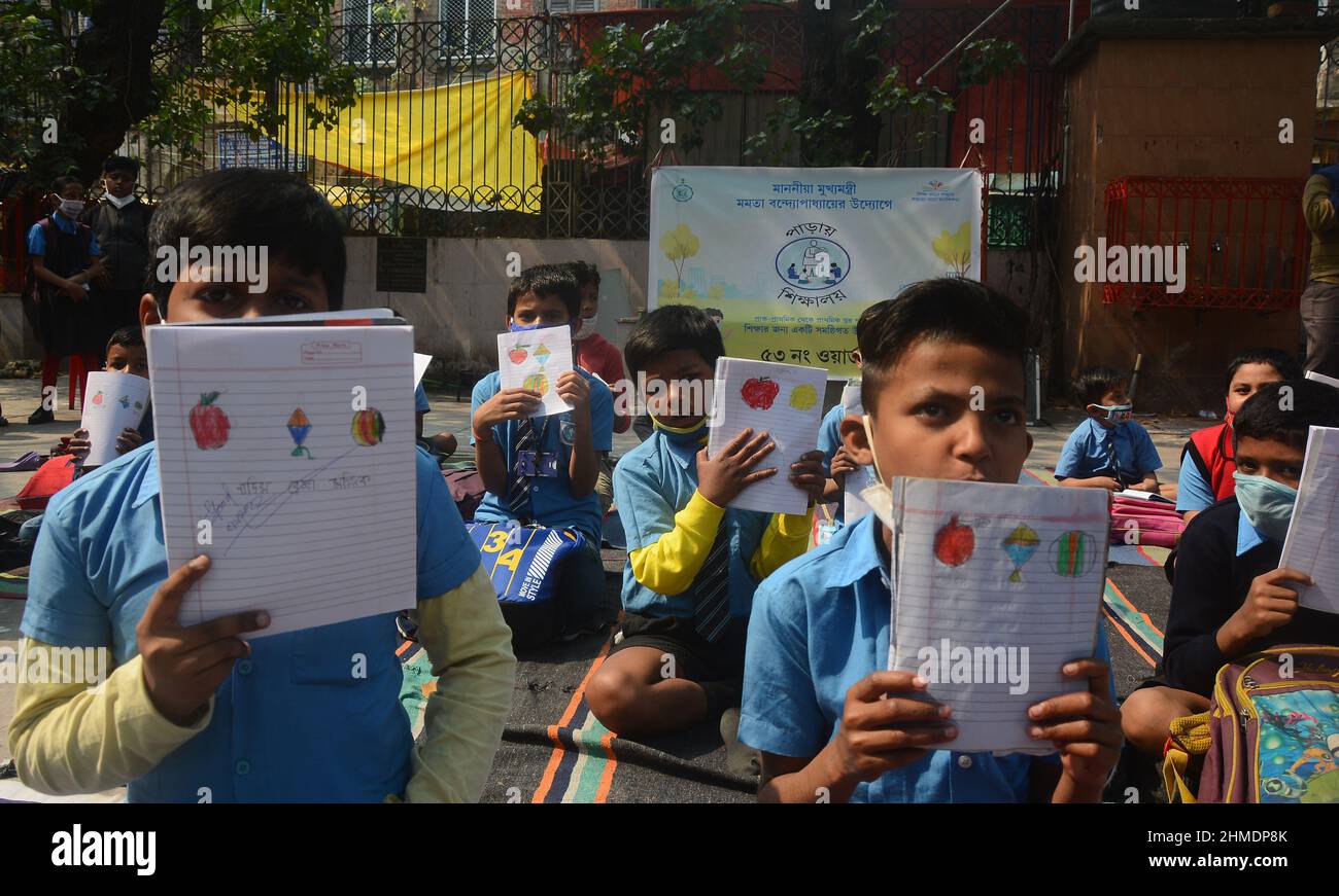 Kolkata, Bengala Occidentale, India. 8th Feb 2022. Le sorelle giocavano con gli studenti in un'aula all'aperto. Gli studenti sono venuti a terra la mattina per lo studio. Si siedono a terra mantenendo protocolli covidi. Indossano maschere. Gli studenti dello stato non sono stati in grado di andare a scuola per molto tempo. Specialmente studenti di classe inferiore. In quest’ottica, il governo statale sta lanciando un progetto per insegnare ai bambini in diverse parti del paese. È stato chiamato ''˜Paraya Shikshalay'. Gli studenti saranno insegnati in uno spazio aperto nel quartiere. L'obiettivo di questo progetto è Th Foto Stock