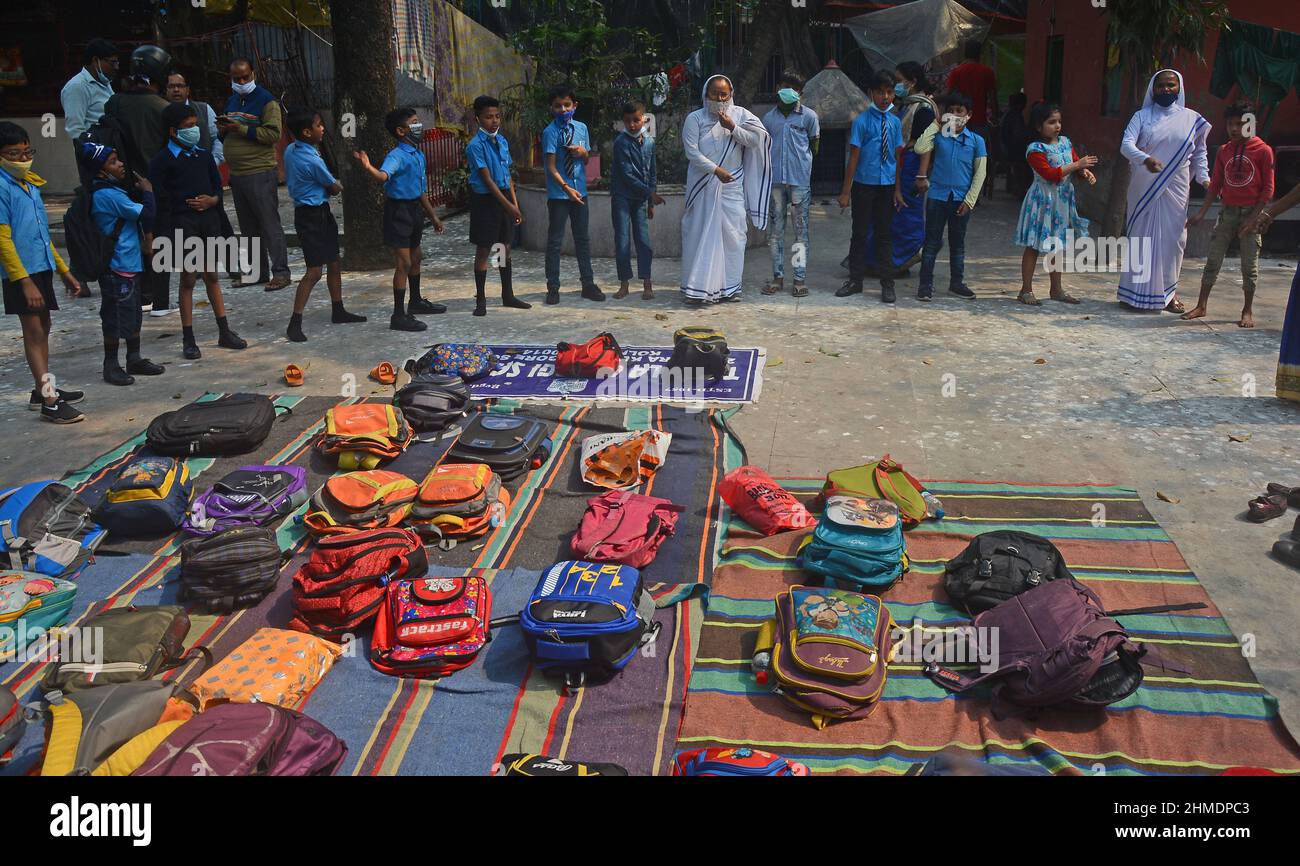 Kolkata, Bengala Occidentale, India. 8th Feb 2022. Le sorelle giocavano con gli studenti in un'aula all'aperto. Gli studenti sono venuti a terra la mattina per lo studio. Si siedono a terra mantenendo protocolli covidi. Indossano maschere. Gli studenti dello stato non sono stati in grado di andare a scuola per molto tempo. Specialmente studenti di classe inferiore. In quest’ottica, il governo statale sta lanciando un progetto per insegnare ai bambini in diverse parti del paese. È stato chiamato ''˜Paraya Shikshalay'. Gli studenti saranno insegnati in uno spazio aperto nel quartiere. L'obiettivo di questo progetto è Th Foto Stock