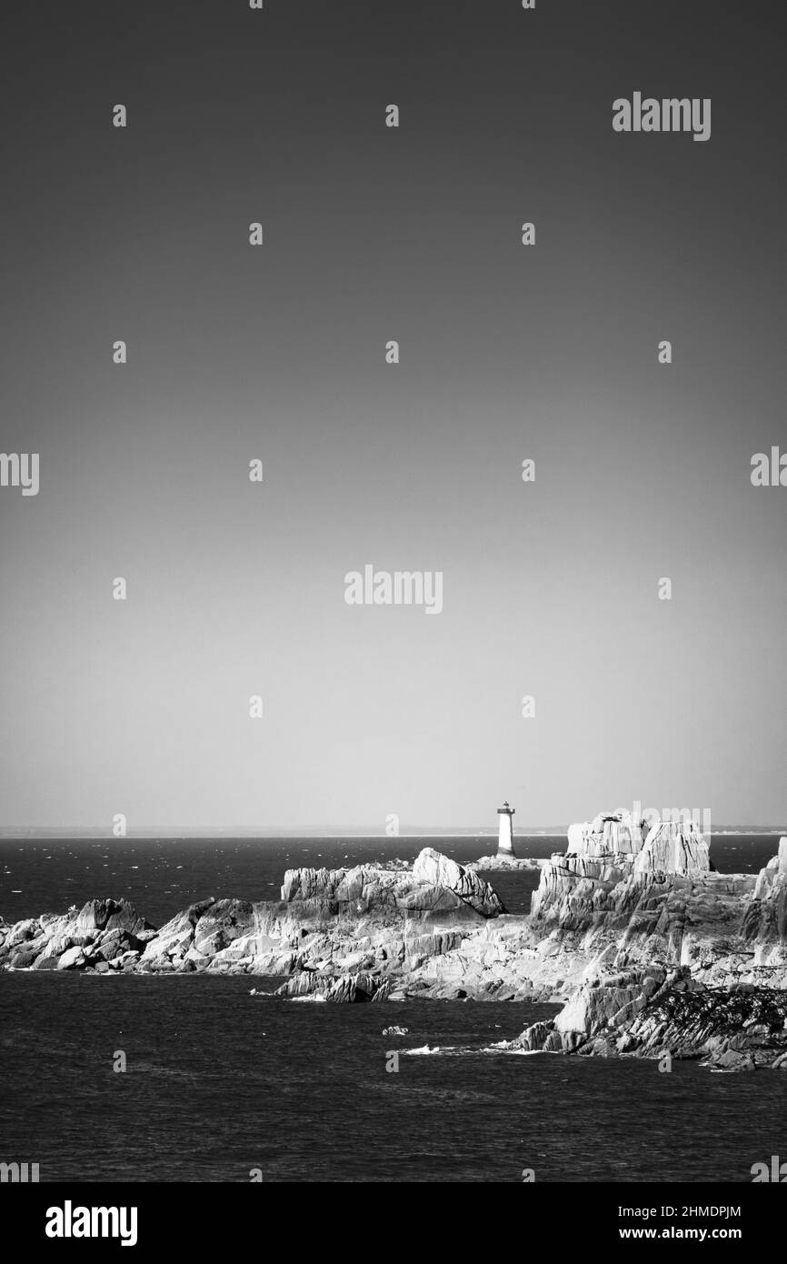 Vista del faro con scogliera rocciosa sul mare contro il cielo, Bretagna, Francia Foto Stock