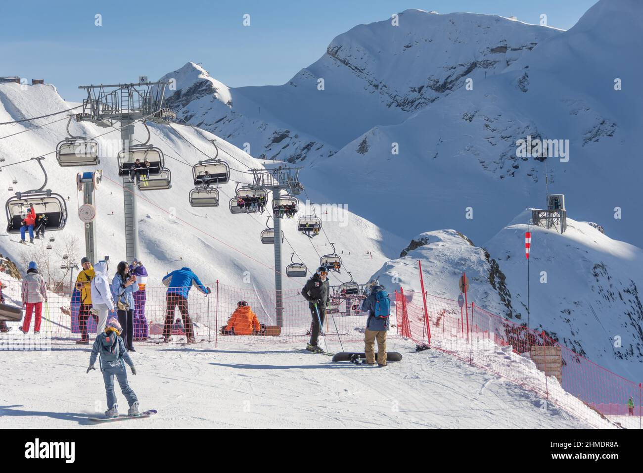 Vista della stazione sciistica - montagne, impianti di risalita, cime innevate. Sciatori e snowboarder ricreativi. Russia, Sochi - Krasnaya polyana. 30 dicembre 2021 Foto Stock