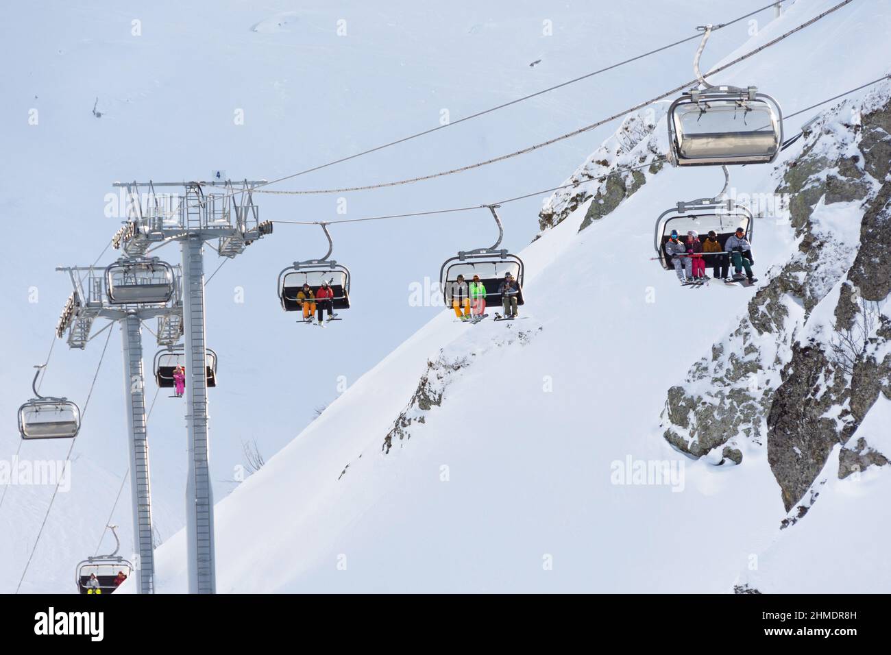 Vista della stazione sciistica - montagne, impianti di risalita, cime innevate. Sciatori e snowboarder ricreativi. Russia, Sochi - Krasnaya polyana. 30 dicembre 2021 Foto Stock