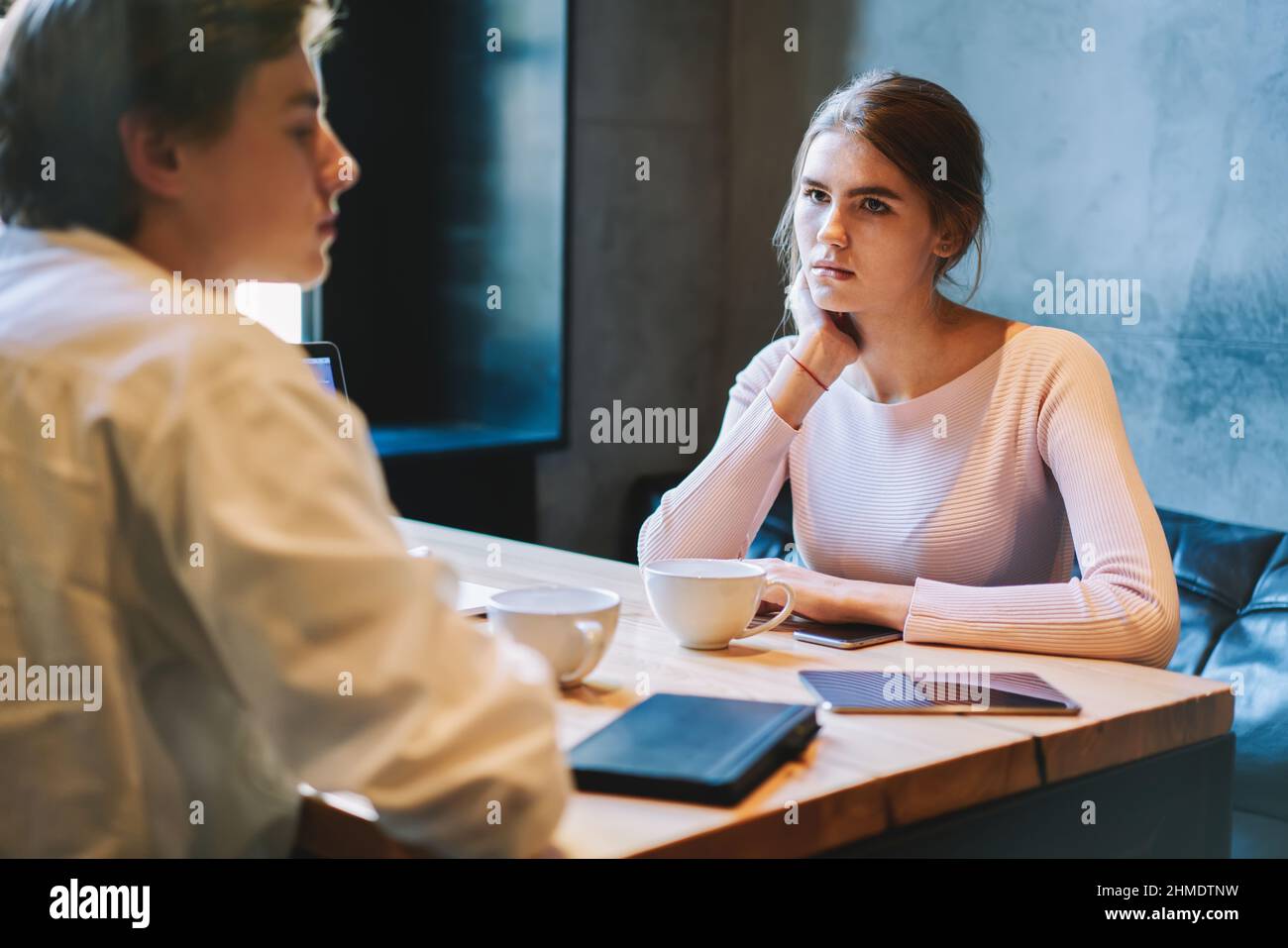 Donna che guarda l'uomo mentre si siede in un bar Foto Stock