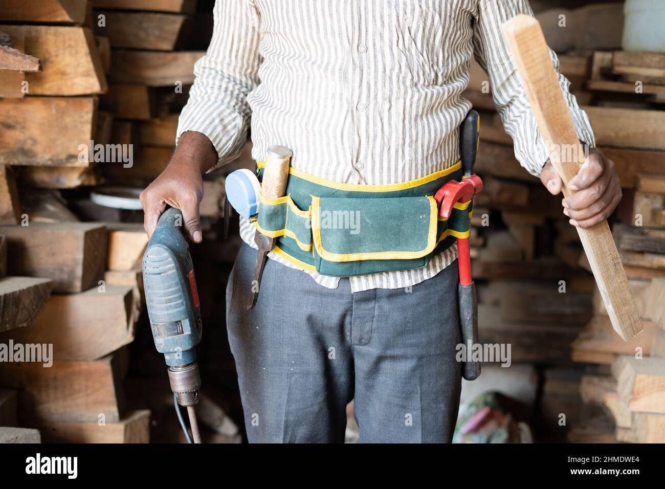 carpentiere irriconoscibile che gira mostrando gli attrezzi di carpenteria con la borsa dell'attrezzatura sul posto di lavoro - concetto di artigiano professionale, di falegnameria e. Foto Stock