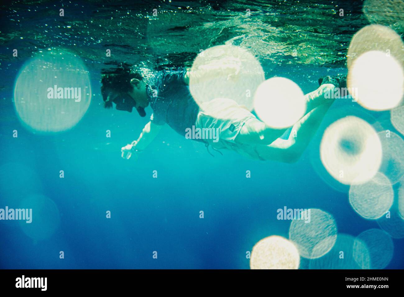 Ragazzo che indossa maschera subacquea nuoto sotto l'acqua Foto Stock