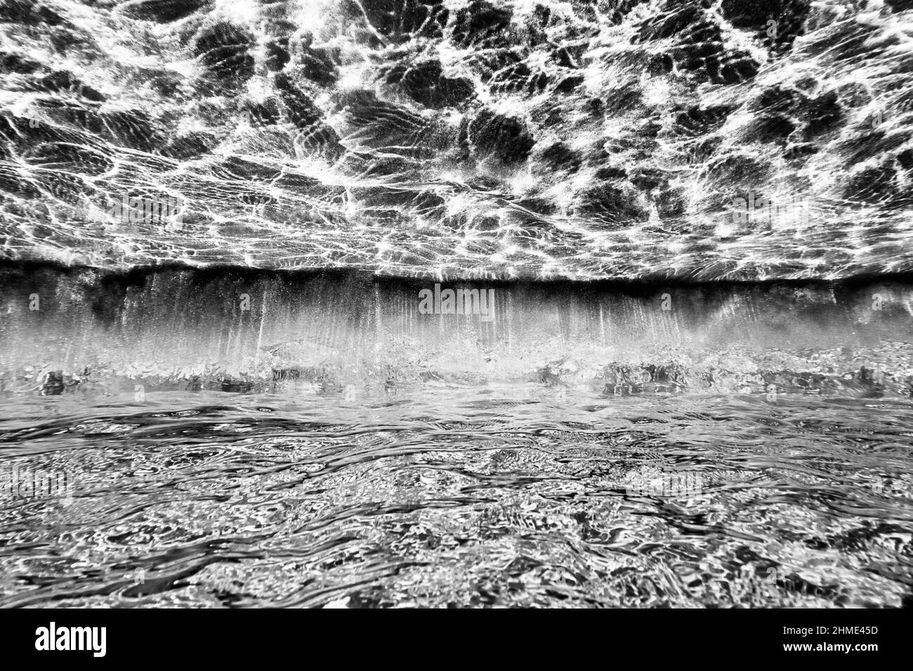 Motivi di texture da raggi di luce che si riflettono sotto l'acqua di mare trasparente Foto Stock