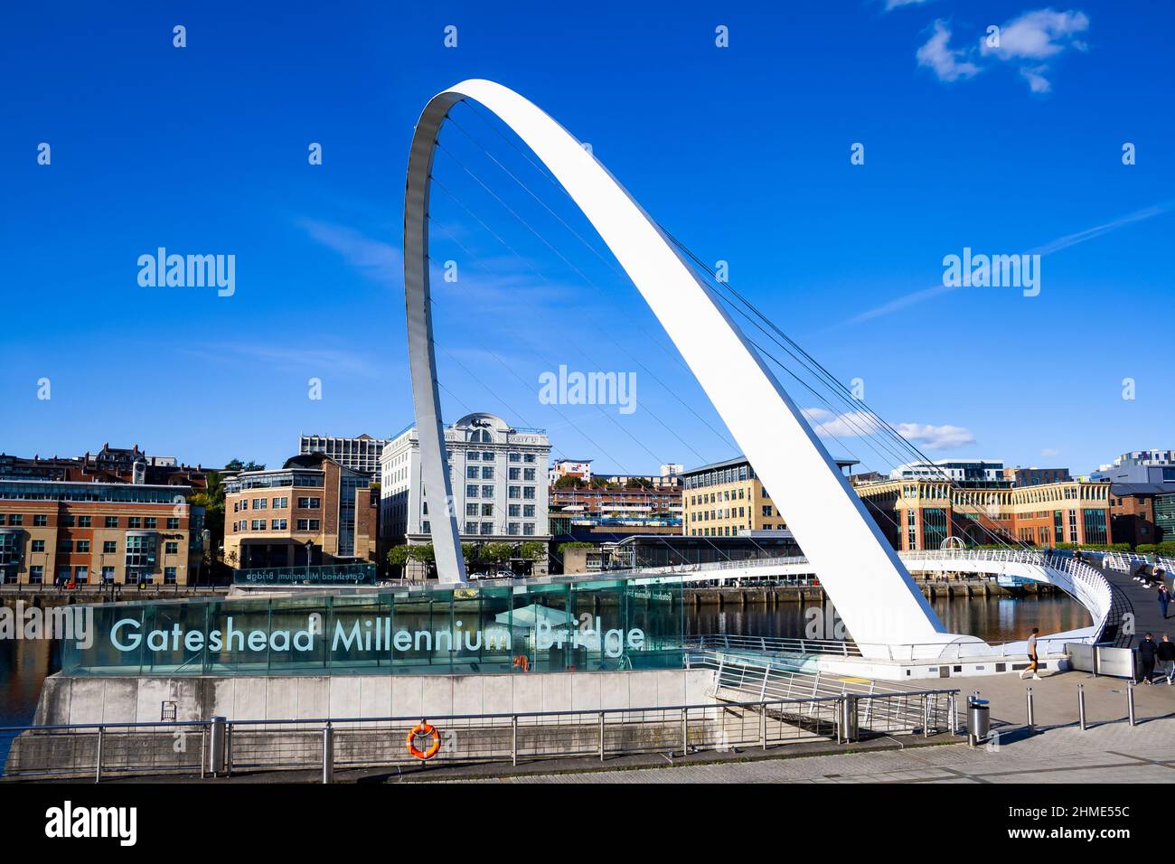 Vista del Gateshead Millennium Bridge a Newcastle upon Tyne e Gateshead (Inghilterra), con Newcastle banchina, in una giornata di sole Foto Stock