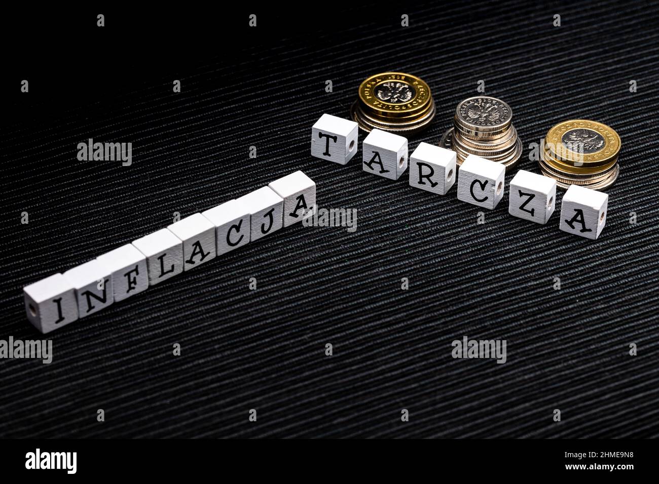 La dicitura 'inflacja' e 'tarcza' si tradusse come 'inflation' e 'hield' più monete polacche su sfondo nero. Nuove norme fiscali in Polonia. H Foto Stock