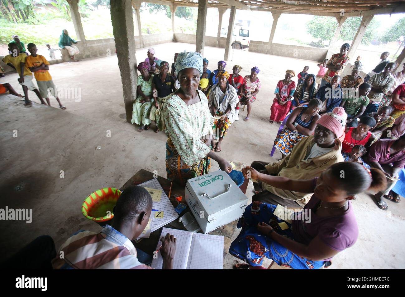 Le persone si riuniscono in una banca comunitaria in Sierra Leone per depositare e risparmiare denaro. Foto Stock