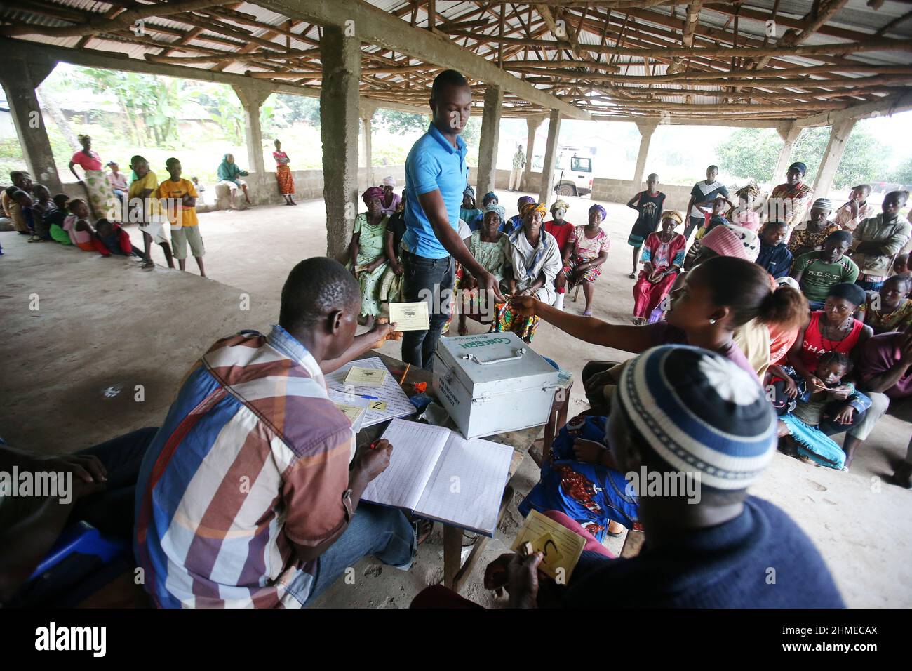 Le persone si riuniscono in una banca comunitaria in Sierra Leone per depositare e risparmiare denaro. Foto Stock