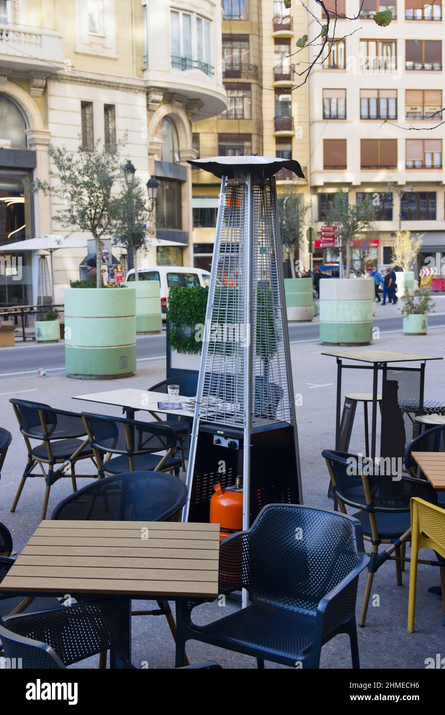 Terrazza di un bar, ristorante o caffè in una grande città che ha una stufa a gas in modo che i clienti seduti ai tavoli all'aperto non si fa freddo in inverno Foto Stock Terrazza di un bar, ristorante o caffè in una grande città che ha una stufa a gas in modo che i clienti seduti ai tavoli all'aperto non si fa freddo in inverno Foto Stock