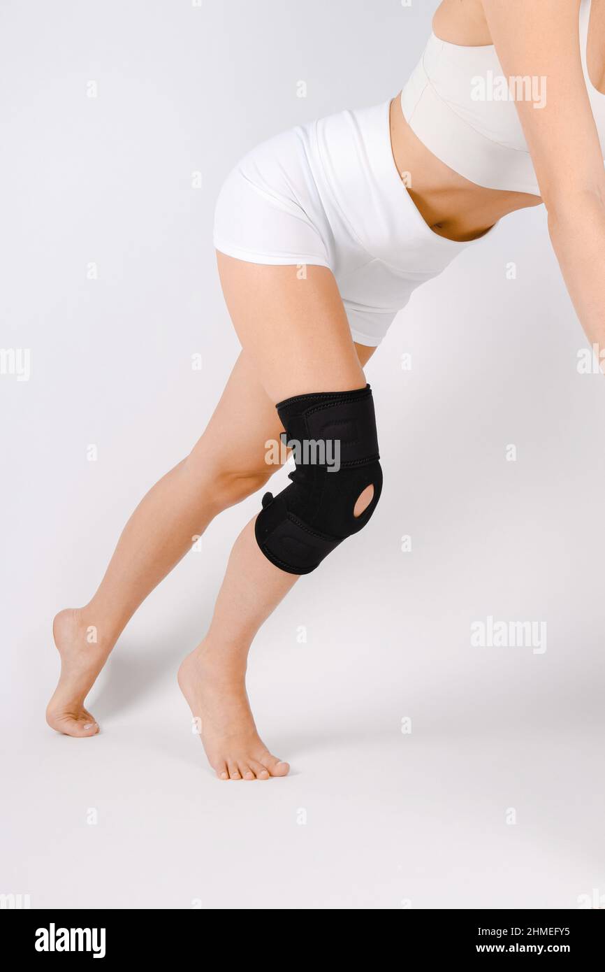 Supporto ginocchia su gamba isolata su sfondo bianco. Ortosi ortopedica elastica. Bretelle anatomiche per fissazione del ginocchio, lesioni e dolore. Protezione Foto Stock